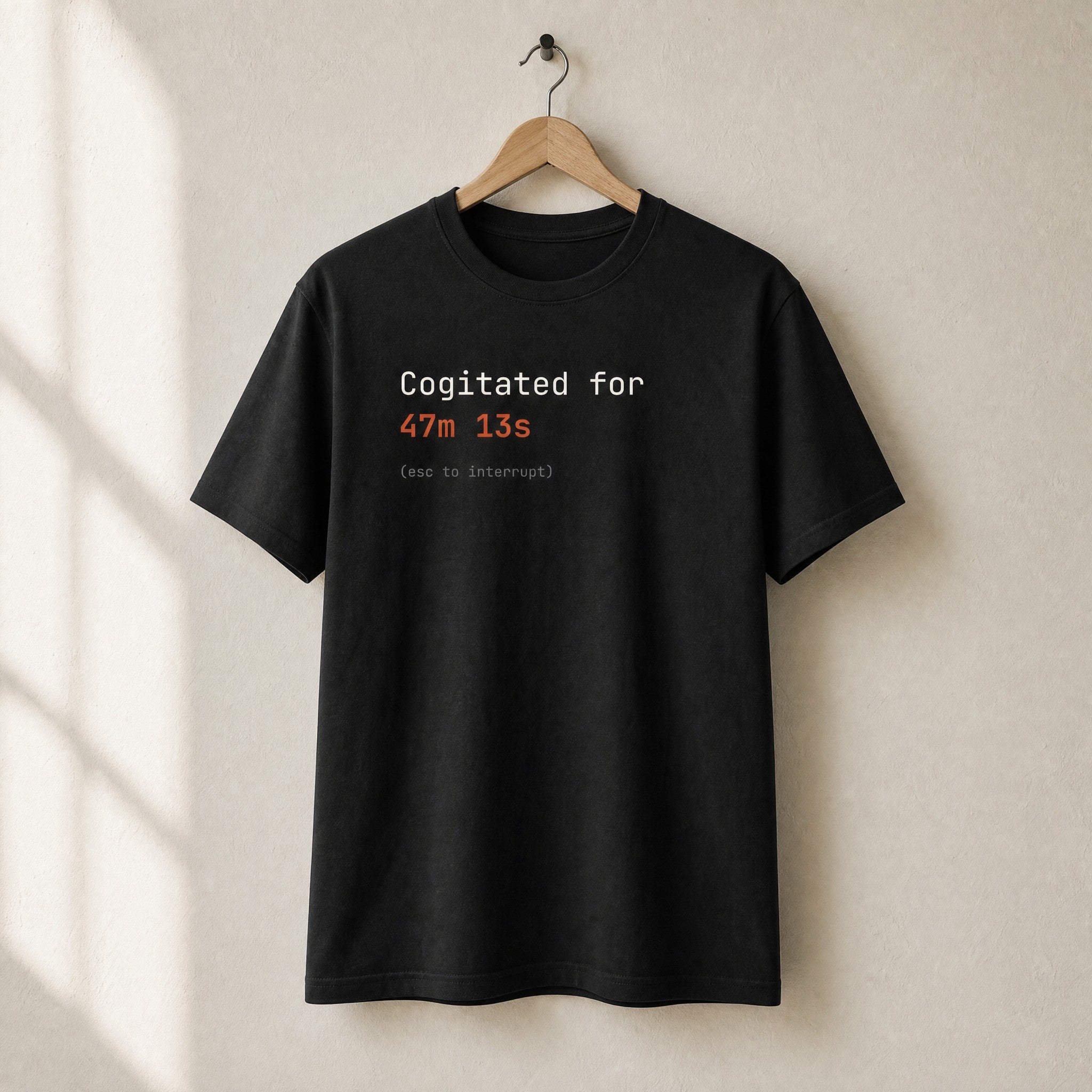 Black Cogitated for 47m 13s t-shirt on a wooden hanger
